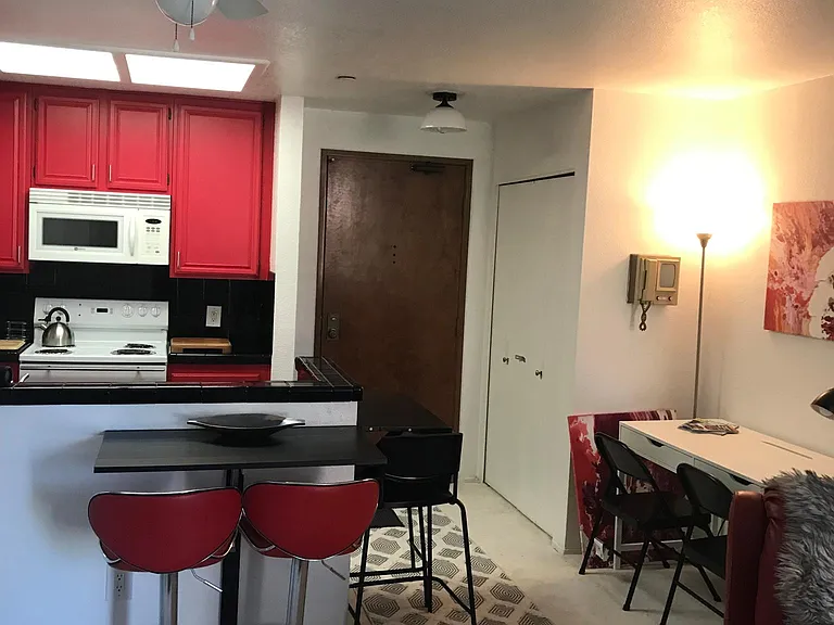 View from living room to the front door. Note convenient drop table dining area or extra work surface.