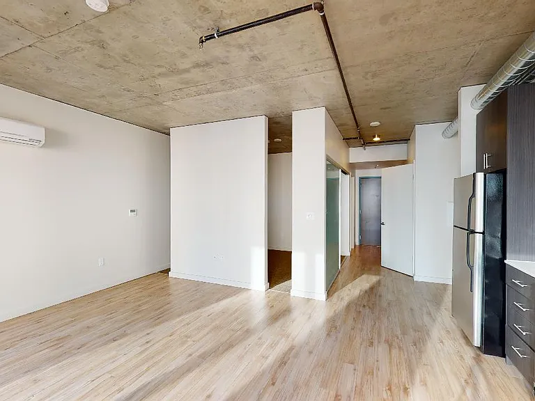 Apartment dining and living room with wood-style flooring.