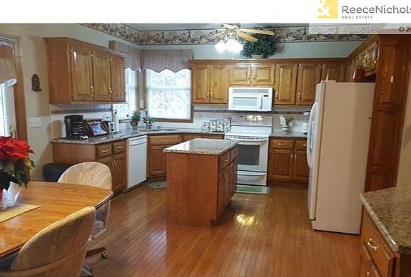 DREAM kitchen, Granite Counter tops, hardwood floor, Island, more cabinets and desk area to right of this photo. Corner Sink overlooks beautiful treed & privacy fenced yard.  All appliances stay.