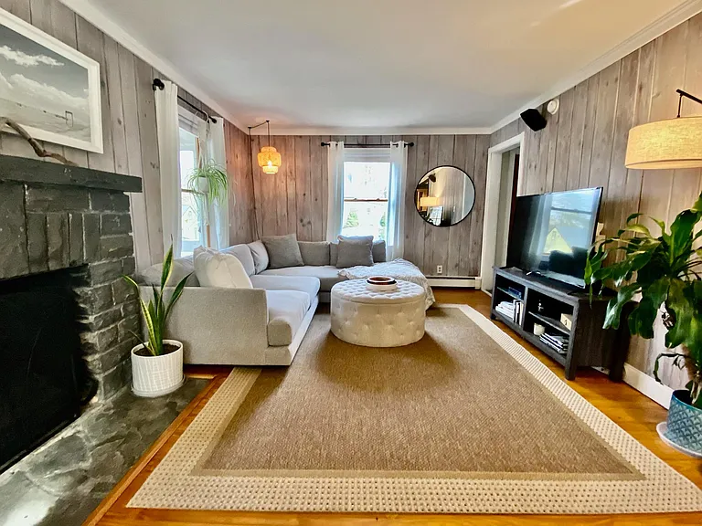 Well lit living room with decorative (only) bluestone fireplace. Slate tiled entry.