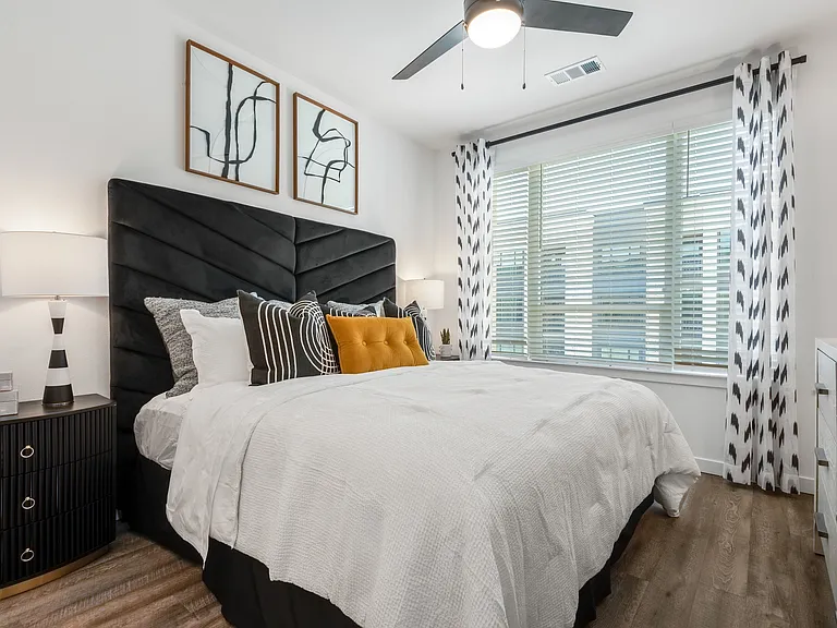 Bedroom with Bold Headboard, Modern Artwork, and Large Window