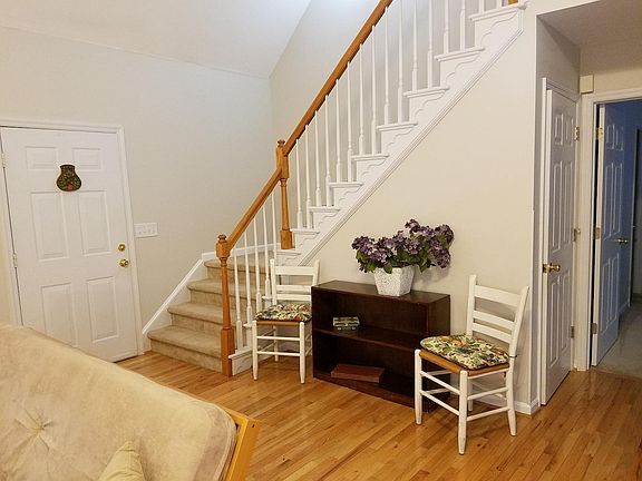 view of front door, living area and steps to 2nd bedroom