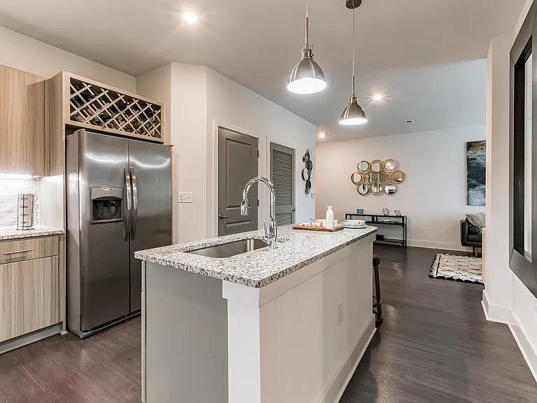 Kitchen Island with Side by Side Fridge and Wine Rack built-in over Fridge. Sink located on the Free Standing Island