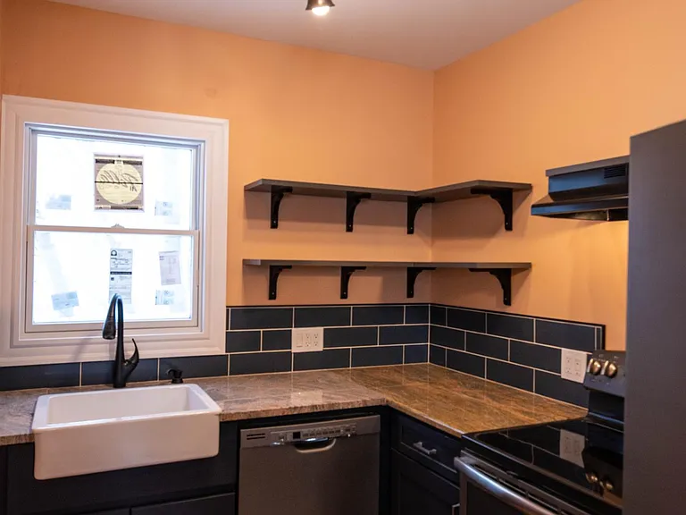close up view including apron farm sink, dishwasher and electric stove