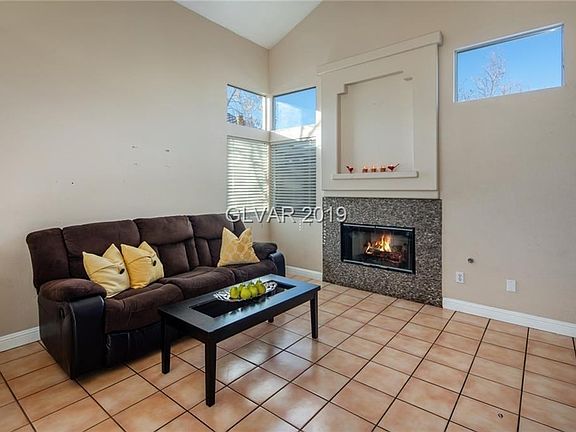 Family room with costume tiled fireplace and soaring high ceiling.