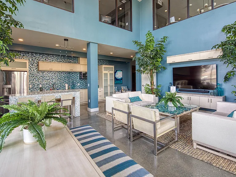 Colorful lounge with patterned tile, tall ceilings, and seating arranged for easy gatherings in our clubroom.