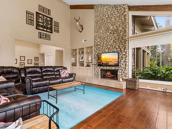 Great room offers panoramic views of the Champions Golf course with floor to ceiling windows, vaulted ceiling, elegant wood beams, updated hard wood floors and marvelous River Rock fireplace.