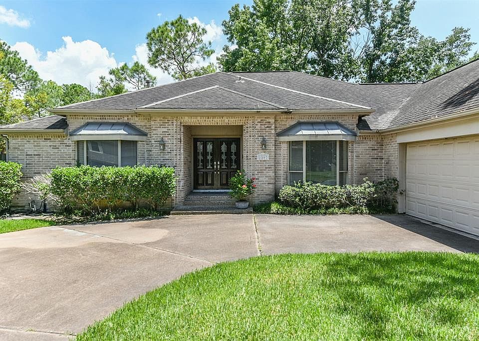 2307 Binley Drive front elevation - Corbeled brick frame the entrance with matching bay windows to either side.