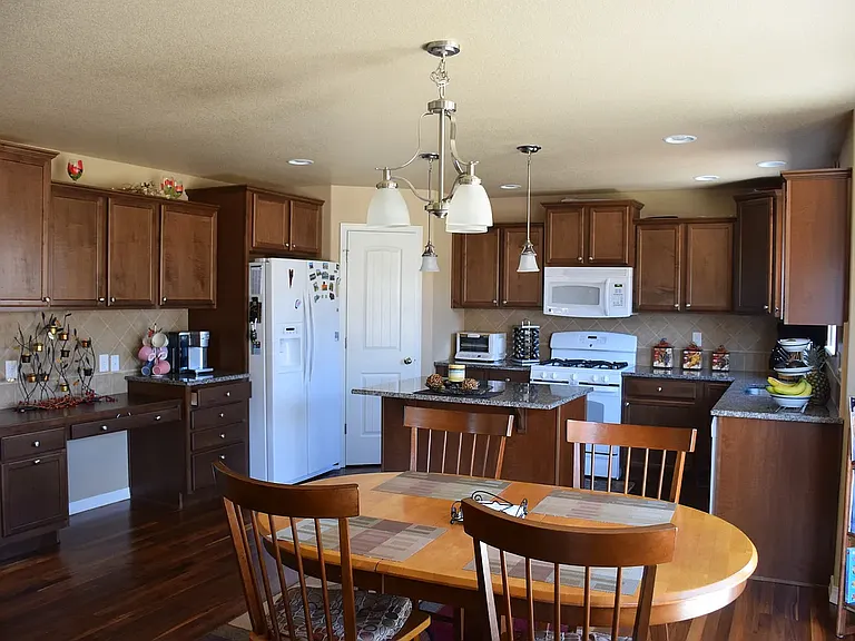 Hardwood floor kitchen with granite countertops and designer cabinets and tile backsplash