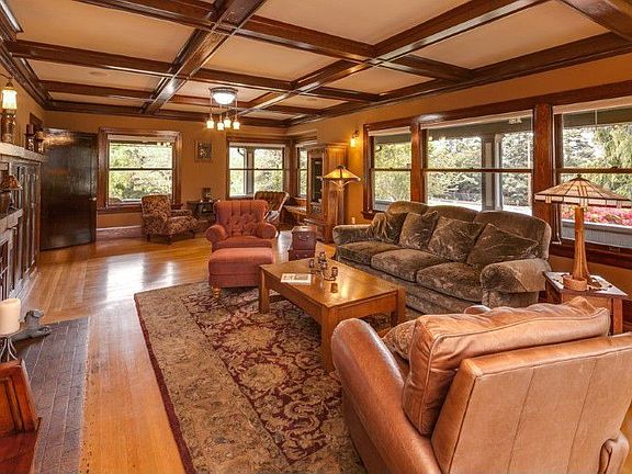 Grand living room w/fireplace and three sitting areas. Incredible woodwork fitting the period of the home.