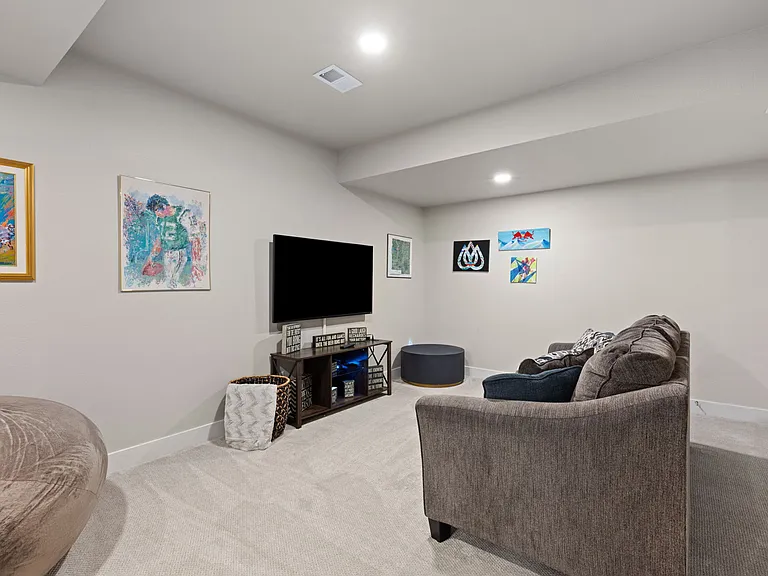 Lower level living room (furniture pictured is for staging purposes only - unfurnished unit)