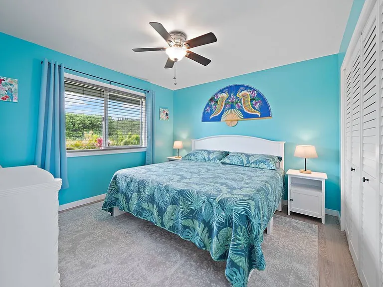 Guest bedroom #1 with king size bed, small dresser and closet.