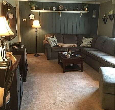 Living room from dining area showing paneled wall/shelf