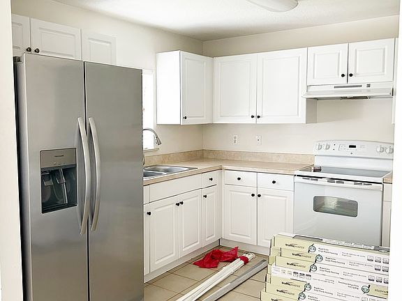 Large kitchen with stainless side by side. Upgraded sink and faucet. This are 2 large closets to the right. One for pantry and the other for washer and dryer.