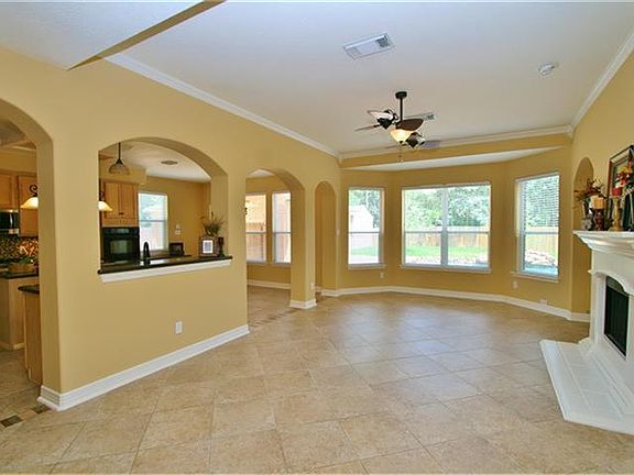 Take a moment and appreciate the details here… tile flooring on an angle, crown molding, the cast stone fireplace, the extended bay windows, and the two sided ceiling fan.