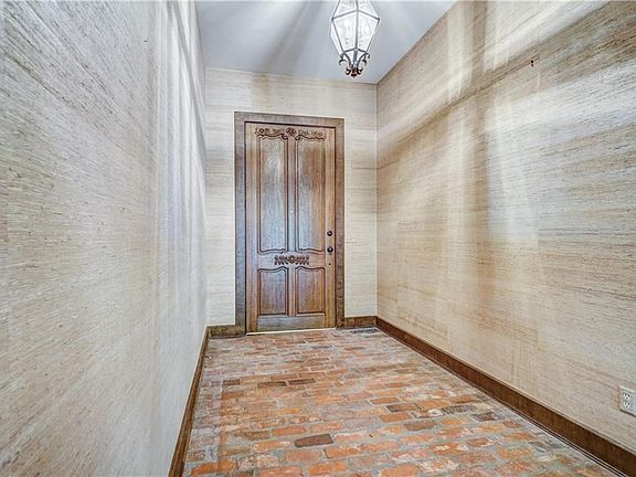 The entry is spectacular with high ceilings, brick floors and check out that ten foot door!