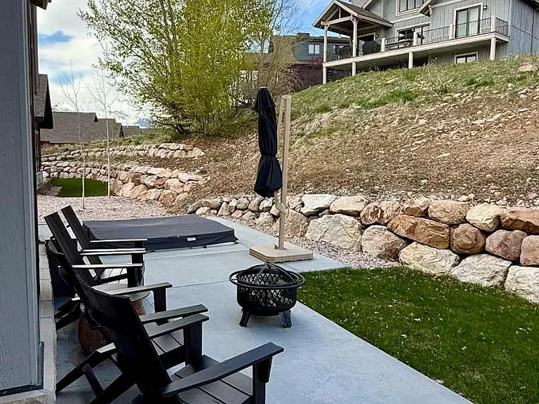 Backyard with private hot tub, patio furniture and wood fire pit