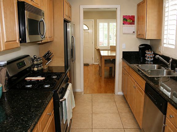 Kitchen with granite countertops, dishwasher, microwave, oven, and refrigerator plus washer and dryer