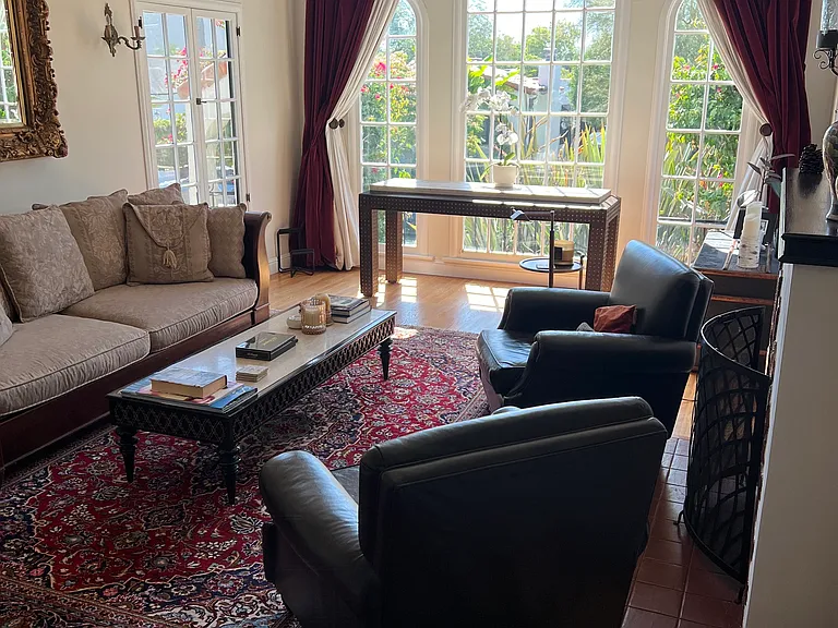 Living room with beamed ceiling and arched picture window