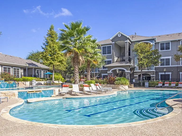 Austin, TX Apartments - Exterior View of Nolina Flats Apartments Building Surrounded By Lush Landscaping with Views of the Pool