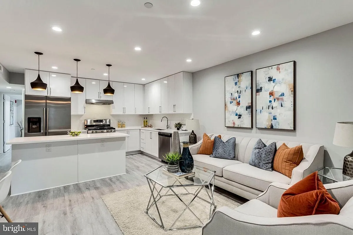 Open-concept living and kitchen area with modern finishes and recessed lighting - 1709 H St NE #1