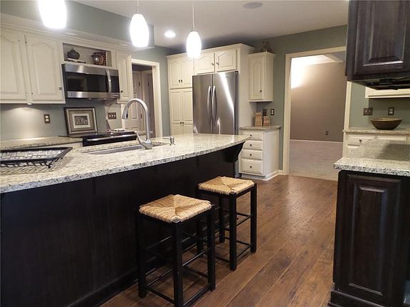The Kitchen was completely renovated:  The doorway seen at the top right was addend so that the floorplan could be more versatile. The views from the island are of the Living Room, the Dining Room, the Screened Porch and the pond.