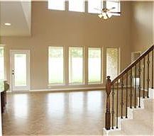 FAMILY ROOM WITH HIGH CEILING, CORNER FIREPLACE AND TILE FLOORS.