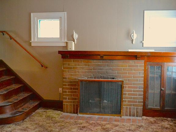 Wood burning fireplace with built in cabinet to the right.