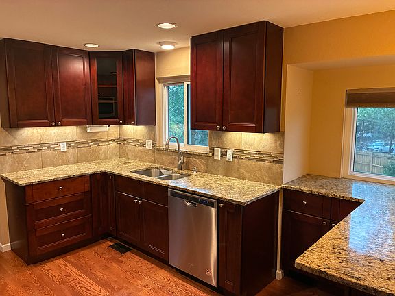 Full kitchen with stainless steel & tons of cabinets under huge island that has a charging station.