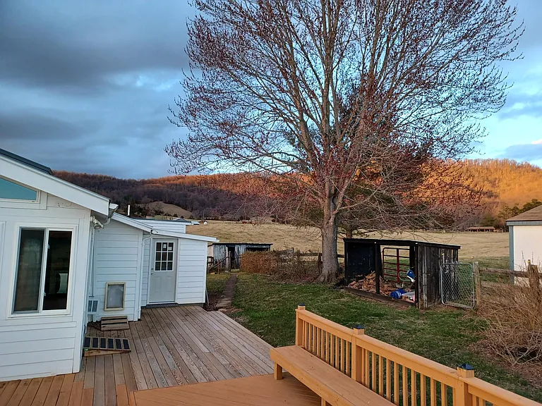 Back of cottage, woodshed, and red maple tree