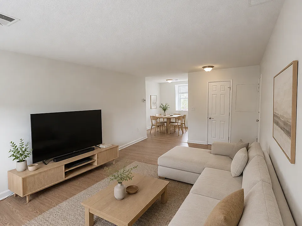 Bright living area featuring two windows, updated flooring, and a flexible layout for relaxing or entertaining.