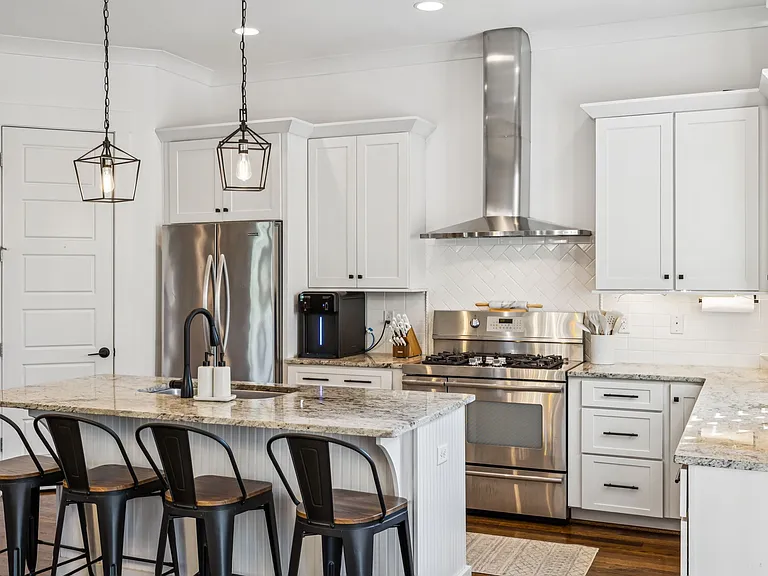 Fully-equipped, modern kitchen with stainless steel appliances, stone countertops, a 5 burner gas stove with double ovens and a walk-in pantry! Seating for 4 at the kitchen island.
