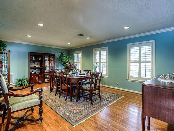 From the foyer you are greeted with the gorgeous dining room with plantation shutters, crown molding, wood floors and recessed lighting. An elegant understated blue gives a refined feel to the room.