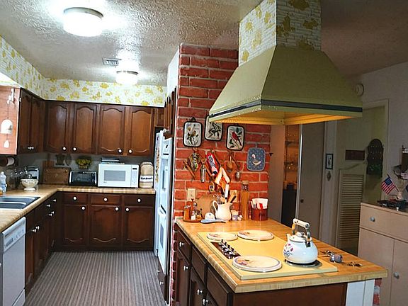 The kitchen has double ovens and a vent hood over the the cook top.
