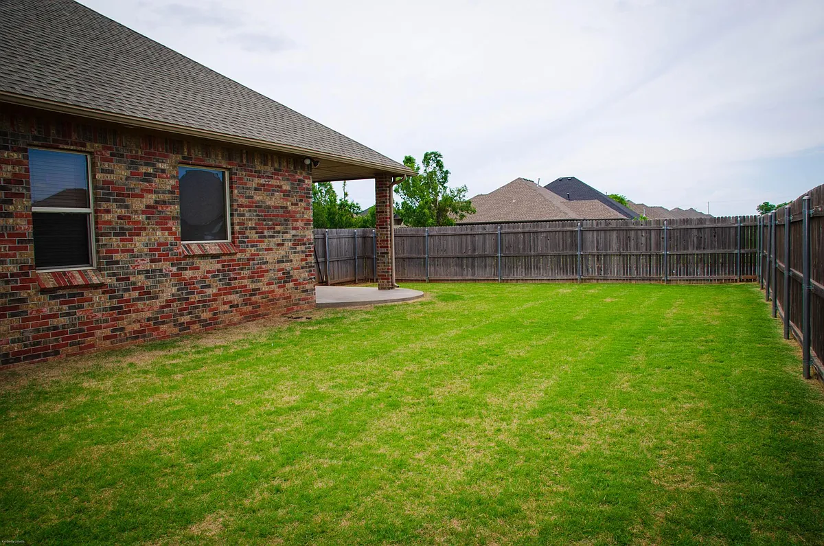 Backyard has a wooden fence protecting the property. Large grassy backyard. - 3513 NW 176th St