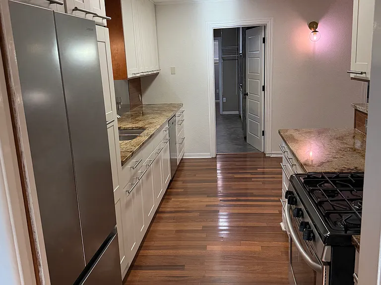 Galley kitchen with open floor plan and pocket door separation from front living area