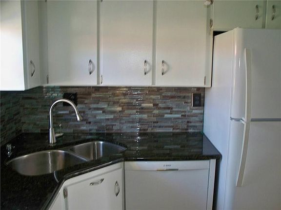 Updated kitchen with granite counter top, glass tiled backsplash