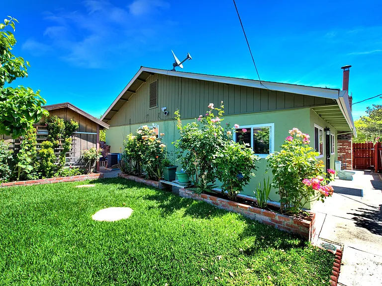 West side of the house, lawn and garden. Entry to house is along the south walkway, right hand side of photo.