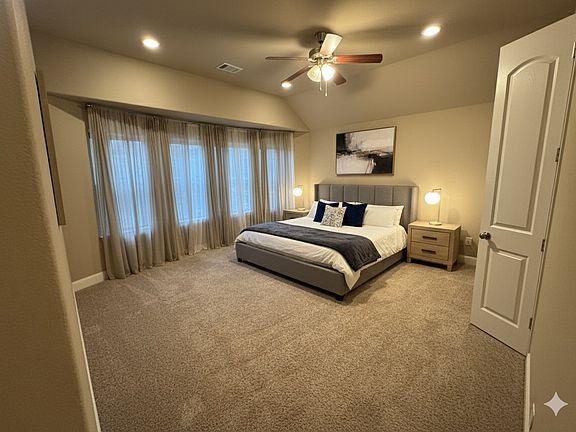 Spacious master bedroom featuring large windows, soft natural light, and plush carpeting _ a peaceful retreat designed for comfort and relaxation.