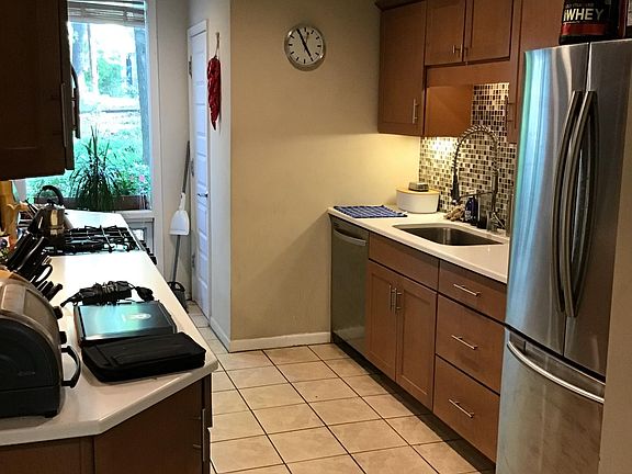 Chefs kitchen, high-end gas range, microwave, commercial style sink with granite counters, stainless steel appliances and dishwasher, ceramic tile floor.