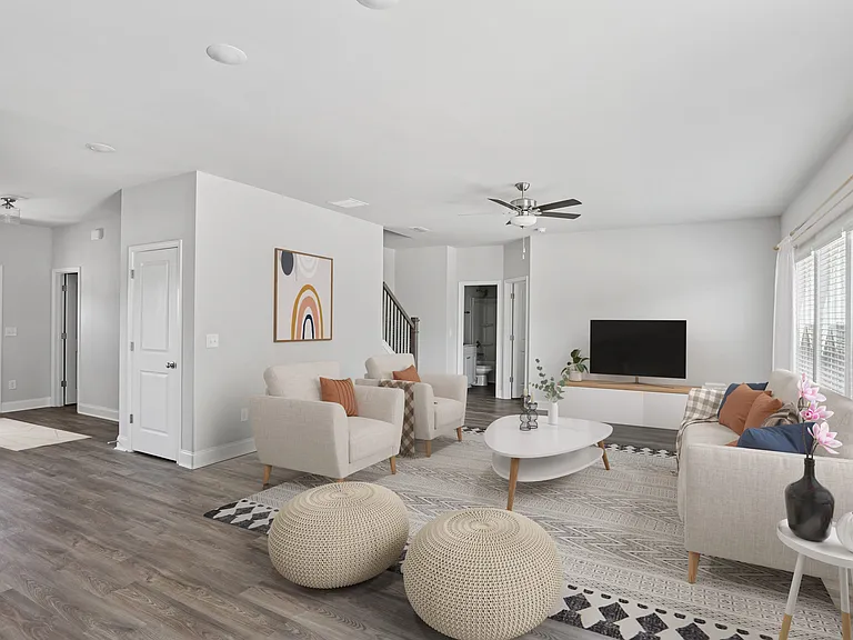 Spacious living room with a plush couch, accent chair, and sleek entertainment center