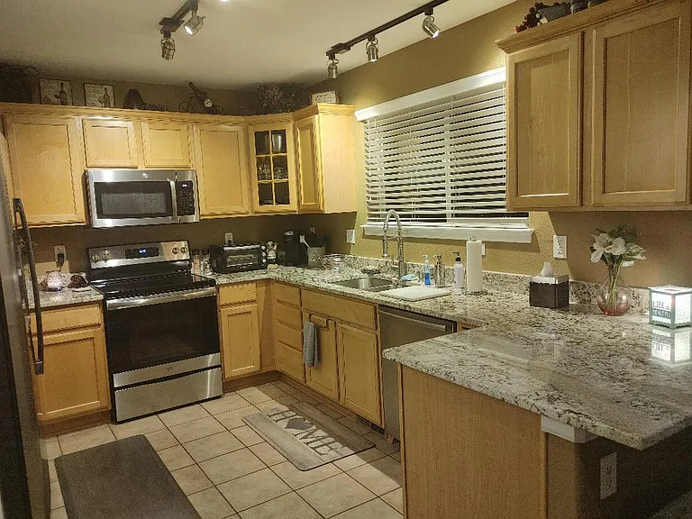 Remodeled kitchen with granite countertops, stainless steel appliances and easy care tile floors