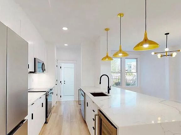 2022 renovated kitchen with waterfall quartz countertops, stainless steel appliances and 2 under-counter beverage fridges. The rear mudroom houses the full size laundry and a full bath rounds out the floor.