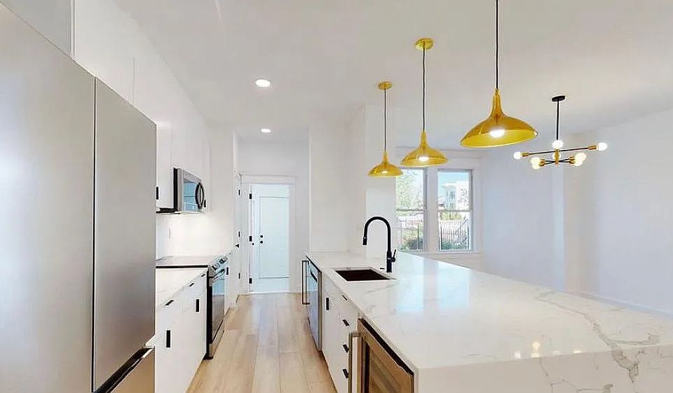 2022 renovated kitchen with waterfall quartz countertops, stainless steel appliances and 2 under-counter beverage fridges. The rear mudroom houses the full size laundry and a full bath rounds out the floor.