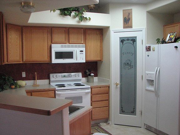 Kitchen has counter seating, stainless steel sink and beautiful pantry door.