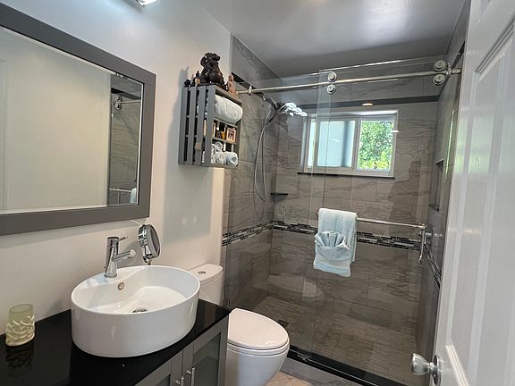Custom glass shower enclosure with water saving toilet and LED lighting.