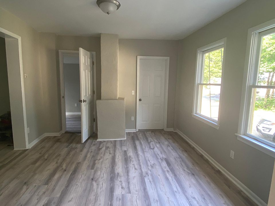 Living room area and open door to extra room/bedroom without closet.