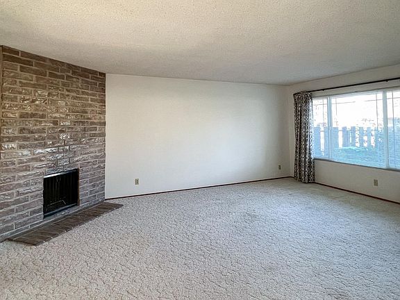 Living room includes large picture window looking out to front yard and street.