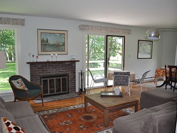 Living room with functional fireplace and door to back deck