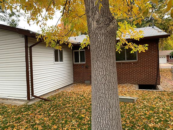 Back of home, showing corner of Family "sun room" addition in the back. Beautiful mature backyard trees (two), provides welcome shade on fully FENCED western facing backyard that opens onto back alley (3 separate gates for access. Two (small) flower/veg